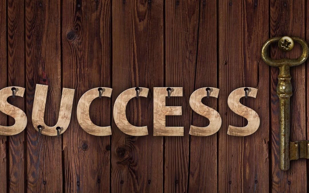 wooden letters spelling the word 'success' next to a metal key